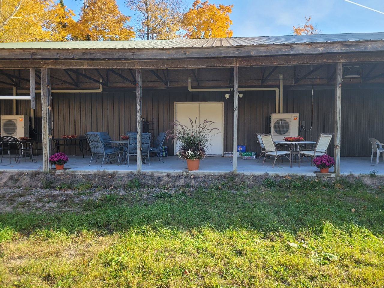 Outdoor covered patio with seating and autumn foliage