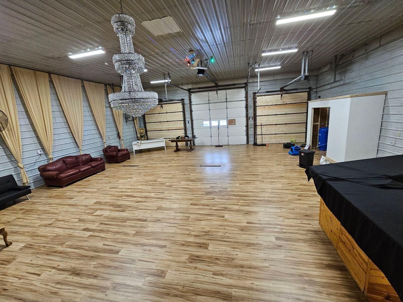 Event hall — hardwood floors, crystal chandelier and stage area